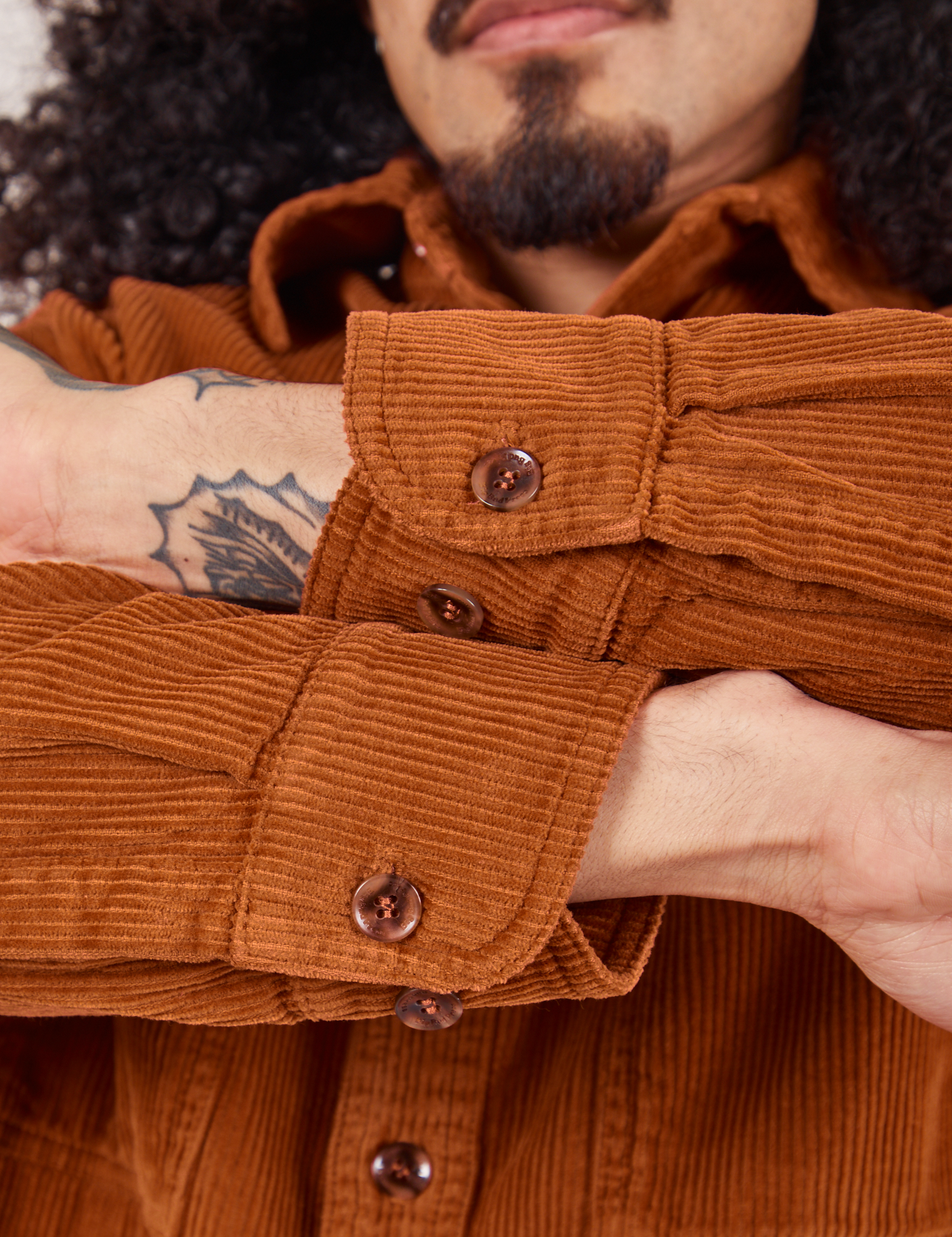 Corduroy Overshirt in Burnt Terracotta close up of sleeve cuffs showing custom tortoise shell buttons