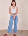 Alex is wearing Cropped Tank Top in Vintage Off-White and light wash Sailor Jeans