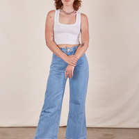 Alex is wearing Cropped Tank Top in Vintage Off-White and light wash Sailor Jeans