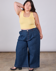 Ashley is wearing Cropped Tank Top in Butter Yellow paired with dark wash Indigo Wide Leg Trousers