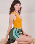 Alex is wearing Painted Stripe Easy Shorts in Dark Emerald Green and golden yellow Cropped Tank