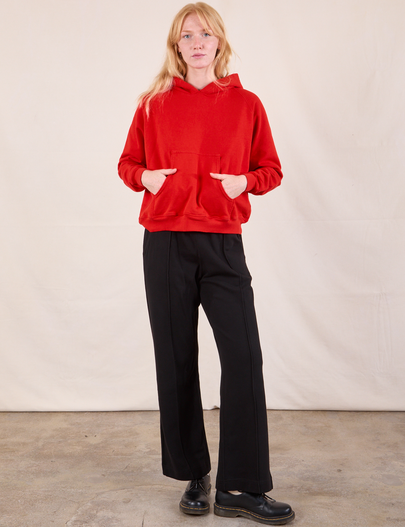 Margaret is wearing Oversized Hoodie in Mustang Red and black Western Pants