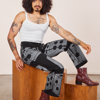 Jesse is sitting on a wooden box wearing Icon Work Pants in Dice and vintage off-white Cropped Cami