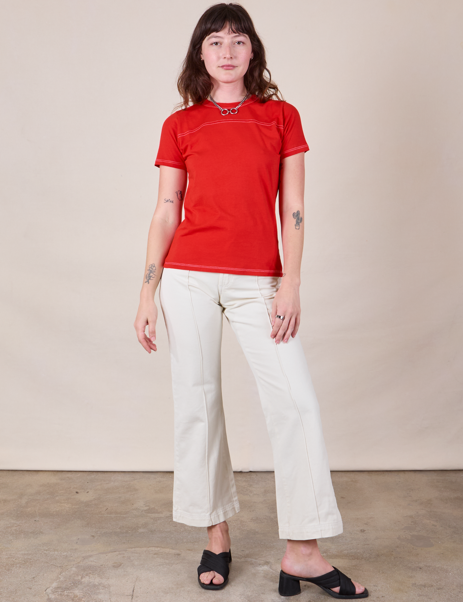 Alex is wearing JV Tee in Mustang Red paired with vintage tee off-white Western Pants