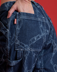 Close up of Alex's hand in the back pocket of Mid-Rise Carpenter Jeans in Chain Link