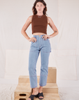 Alex is wearing Muscle Tee in Fudgesicle Brown and light wash Carpenter Jeans