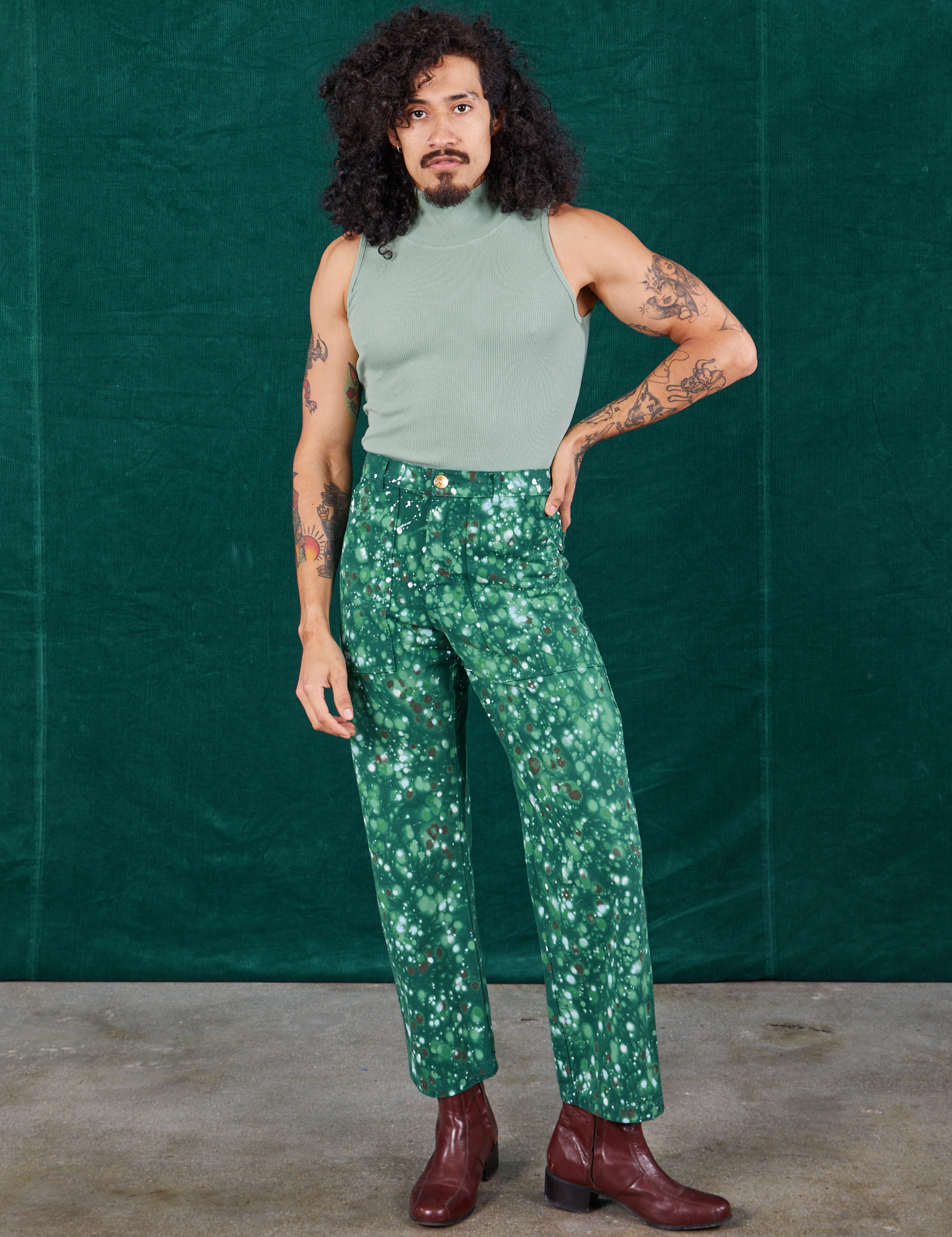 Jesse is 5&#39;8&quot; and wearing XS Marble Splatter Work Pants in Hunter Green paired with sage green Sleeveless Turtleneck