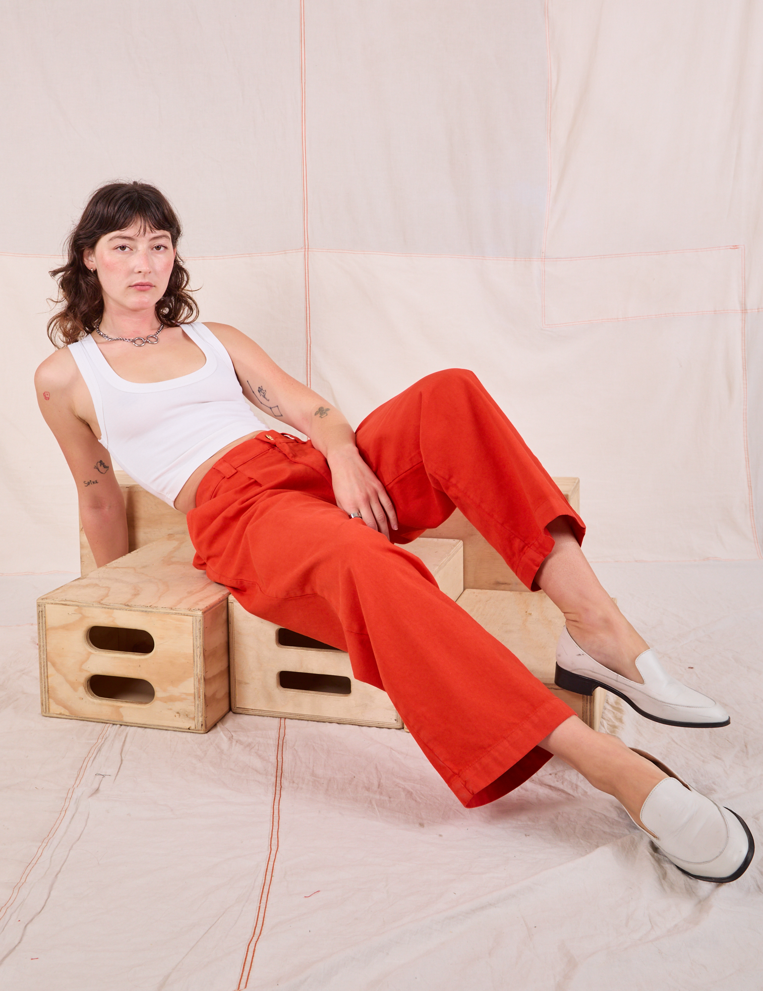 Alex is wearing Mid-Rise Pleated Trousers in Chili Red and Cropped Tank in vintage tee off-white