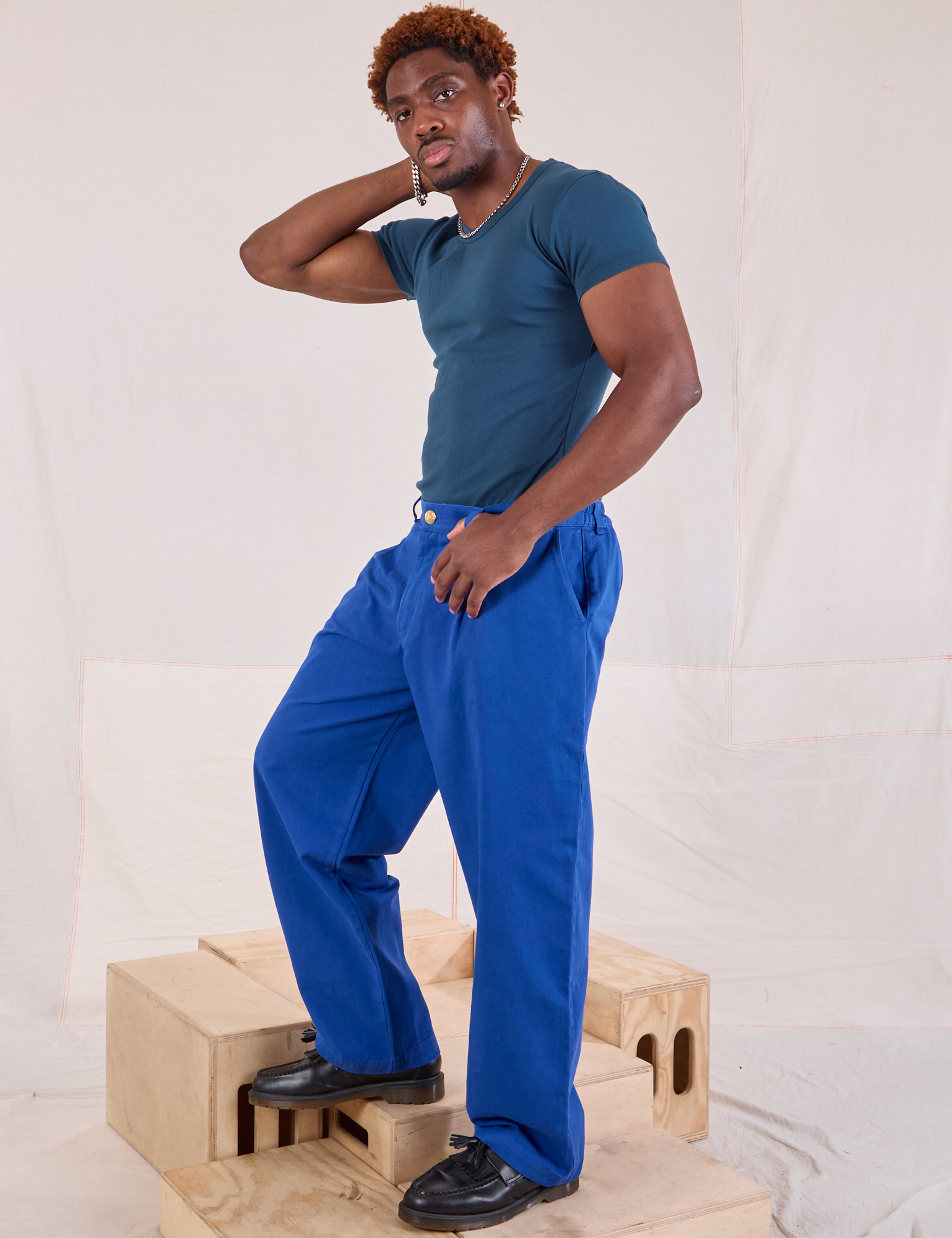 Side view of Mid-Rise Pleated Trousers in Royal Blue and lagoon Baby Tee on Issac