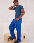 Side view of Mid-Rise Pleated Trousers in Royal Blue and lagoon Baby Tee on Issac