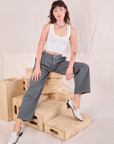 Alex is wearing Mid-Rise Pleated Trousers in Slate Grey and Cropped Tank in vintage tee off-white