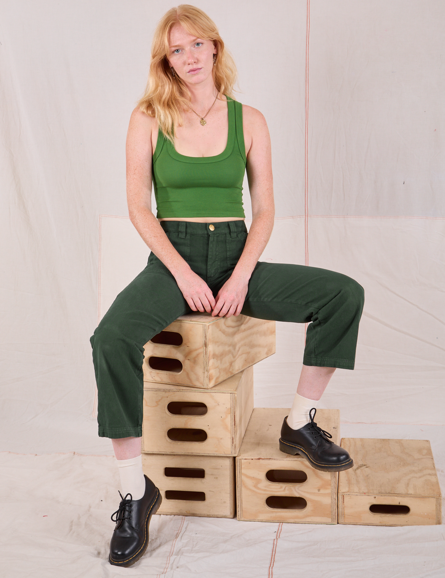 Margaret is wearing Mid-Rise Work Pants in Swamp Green and lawn green Cropped Tank