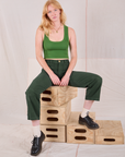 Margaret is wearing Mid-Rise Work Pants in Swamp Green and lawn green Cropped Tank