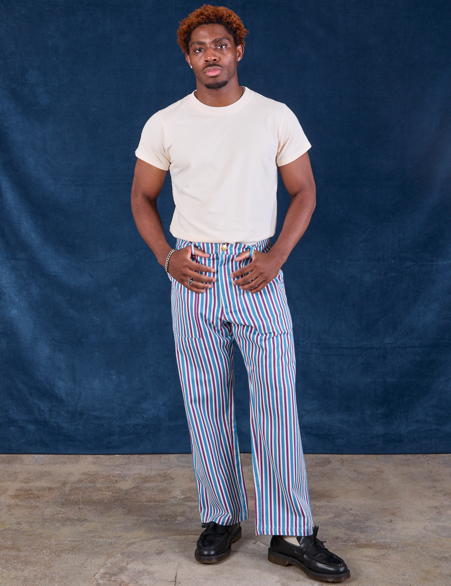 Issac is 5&#39;10&quot; and wearing M Stripe Work Pants in Blue Raspberry paired with Organic Vintage Tee in vintage tee off-white