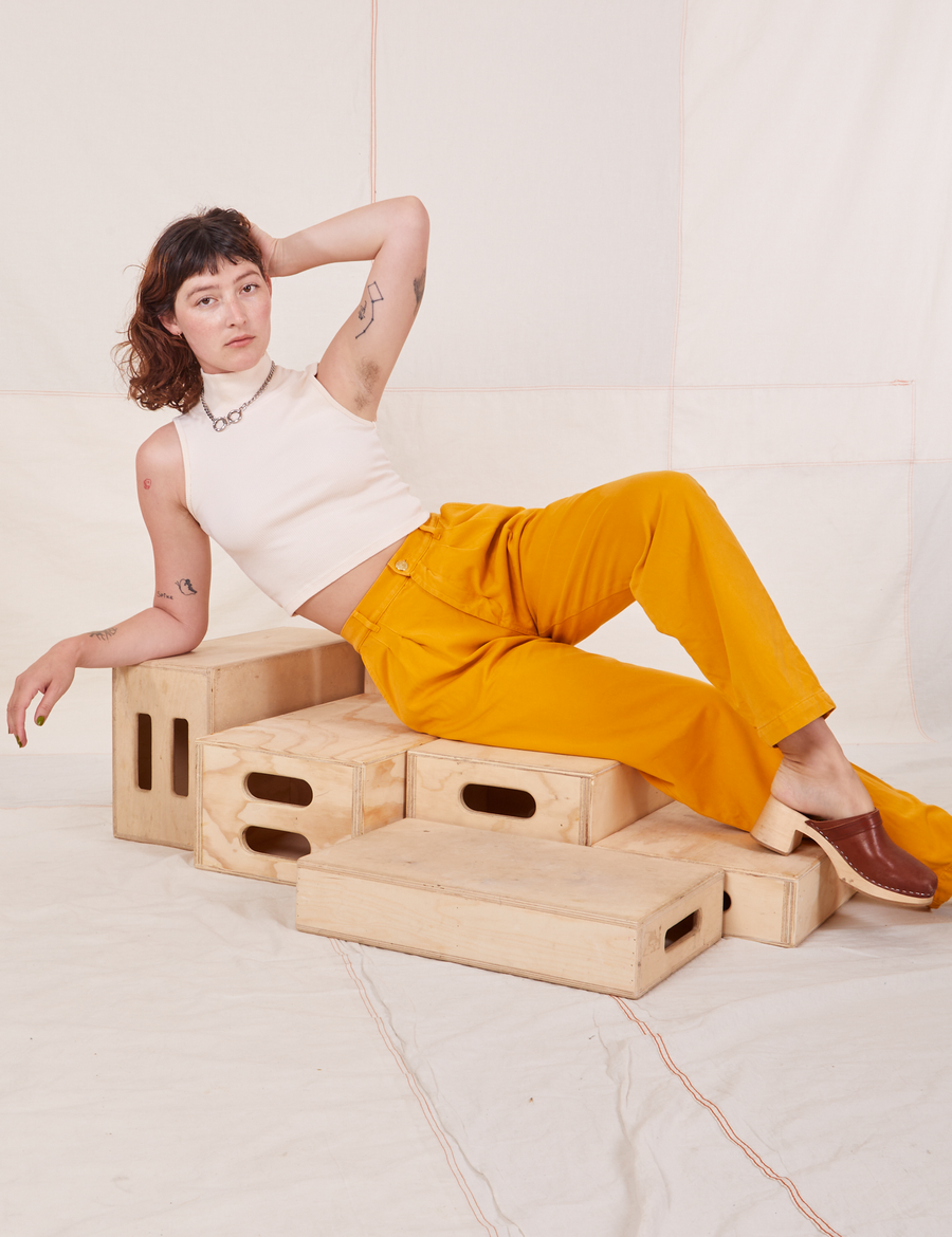 Organic Trousers in Mustard Yellow and vintage off-white Sleeveless Essential Turtleneck worn by Alex