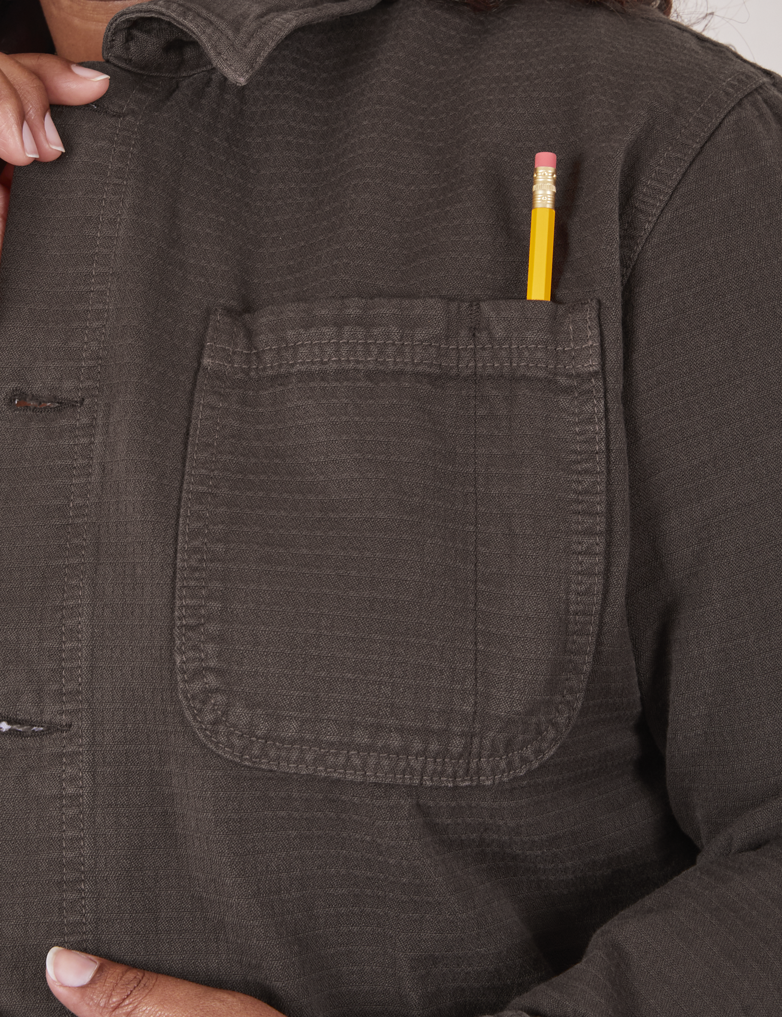 Field Coat in Espresso Brown font pocket close up with pencil in the pen pocket slot