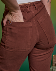 Close up of Alex's hand in the back pocket of Paintstamped Work Pants in Mushroom