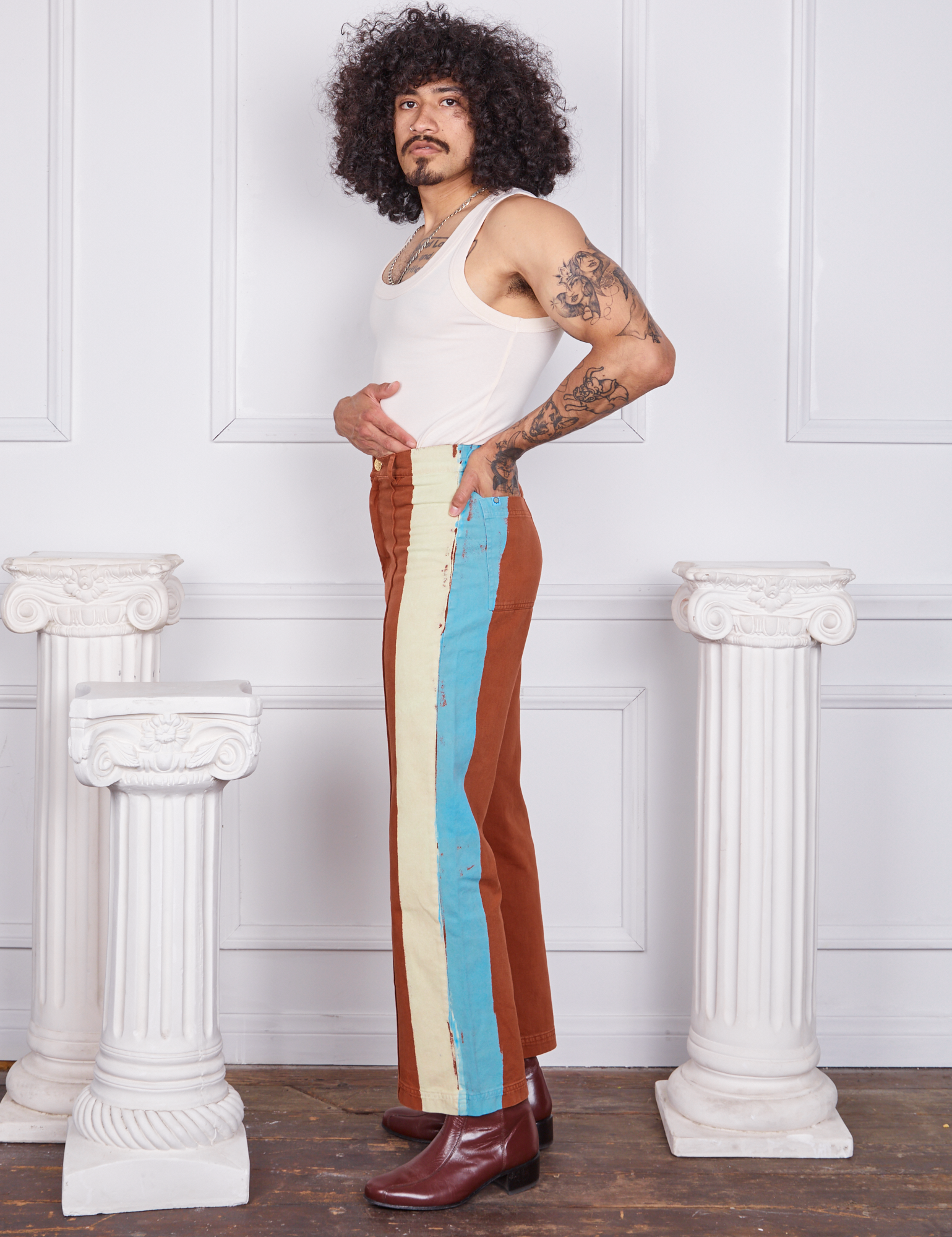 Side view of Hand-Painted Stripe Western Pants in Burnt Terracotta and vintage off-white Tank Top worn by Jesse