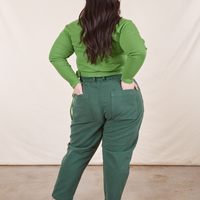 Back view of Pencil Pants in Dark Emerald Green paired with a bright olive Wrap Top worn by Ashley