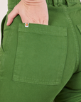 Pencil Pants in Lawn Green back pocket close up. Alex has her hand in the pocket.