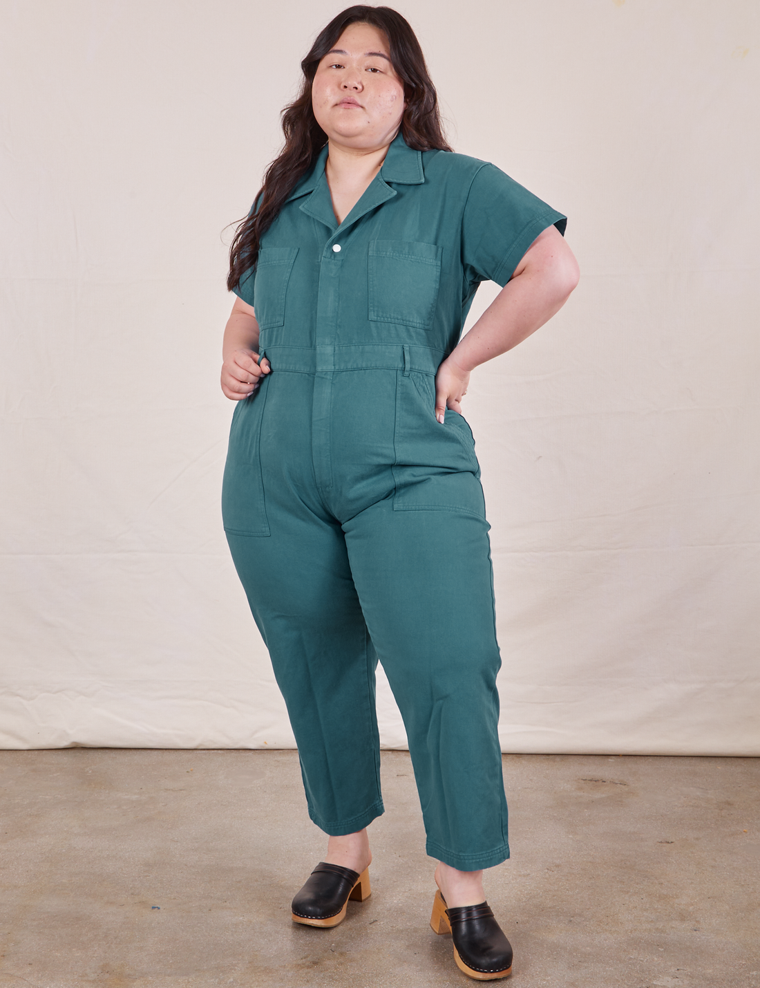 Ashley is 5’7” and wearing 1XL Petite Short Sleeve Jumpsuit in Marine Blue