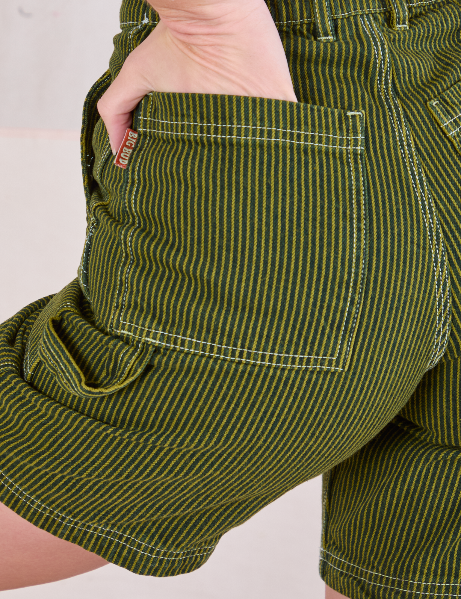 Close up of Alex&#39;s hand in the back pocket of Railroad Carpenter Shorts in Summer Olive