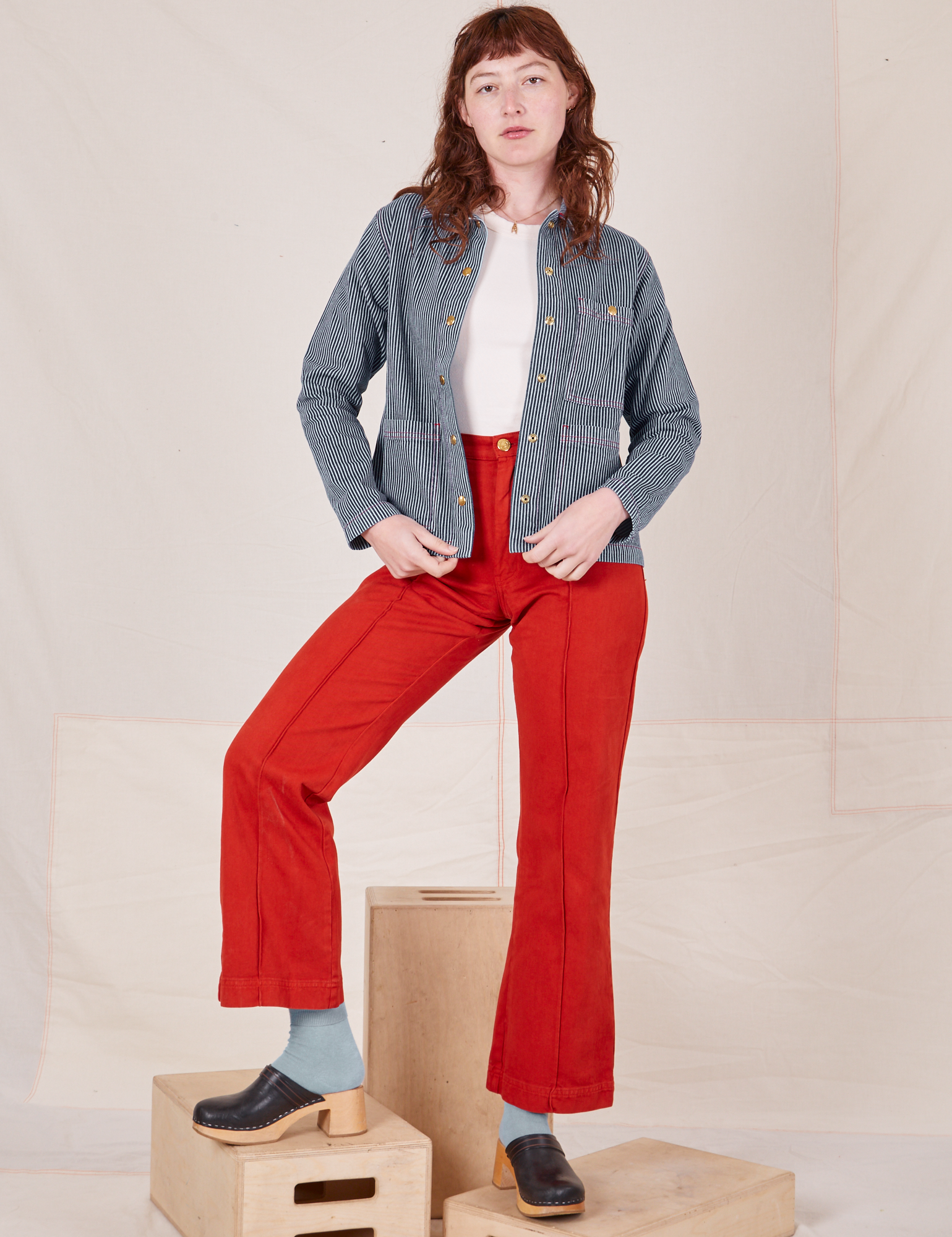 Alex is 5&#39;8&quot; and wearing XXS Railroad Stripe Denim Work Jacket paired with paprika Western Pants