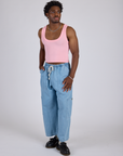 Isaac is wearing Cropped Tank Top in Baby Pink and light wash Denim Drop Pocket Pants