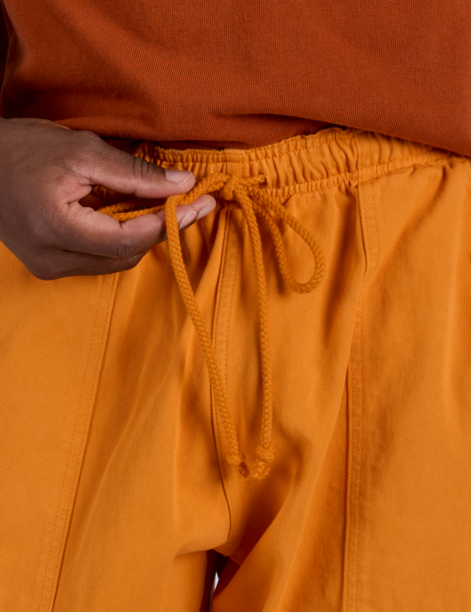 Drop Pocket Cargo Pants in Creamsicle Orange drawstring close up on Isaac