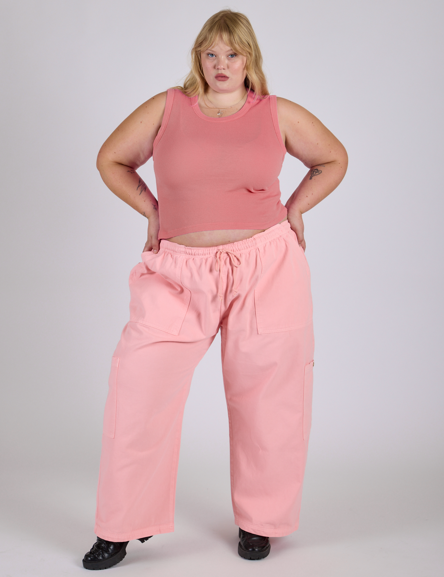Juliet is 5’7” and wearing 2XL Drop Pocket Cargo Pants in Baby Pink paired with a Muscle Tee