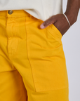 Close up of Isaac's hand in the front pocket of Longline Work Shorts in Sunshine Yellow