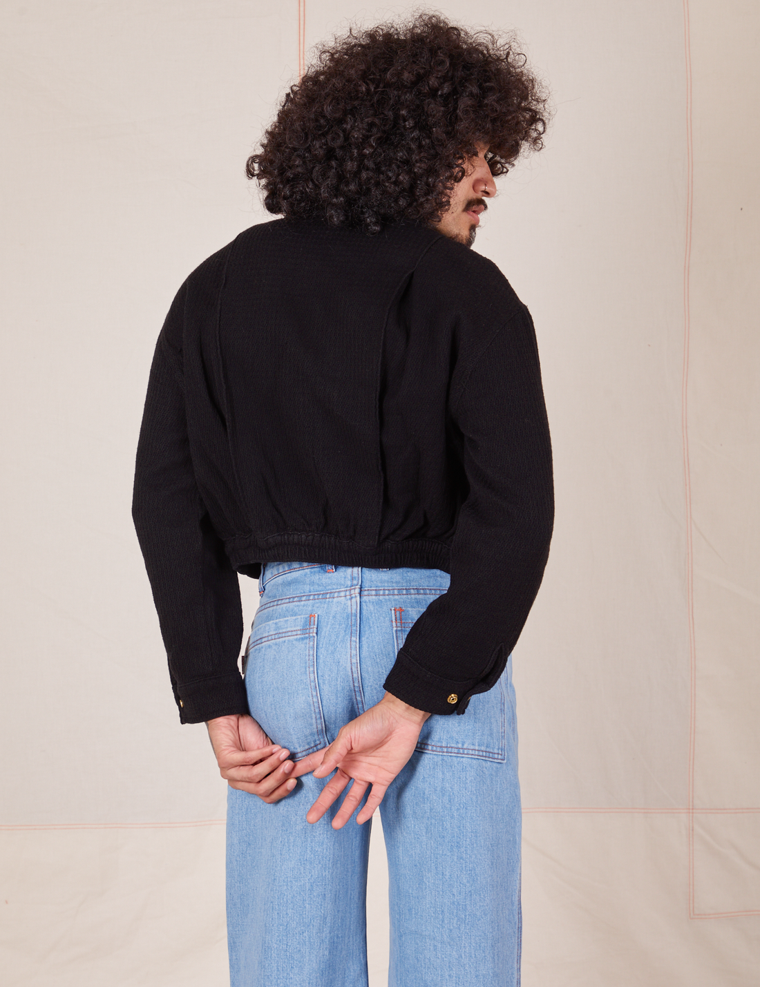 Back view of Ricky Jacket in Basic Black and light wash Sailor Jeans worn by Jesse
