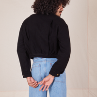 Back view of Ricky Jacket in Basic Black and light wash Sailor Jeans worn by Jesse