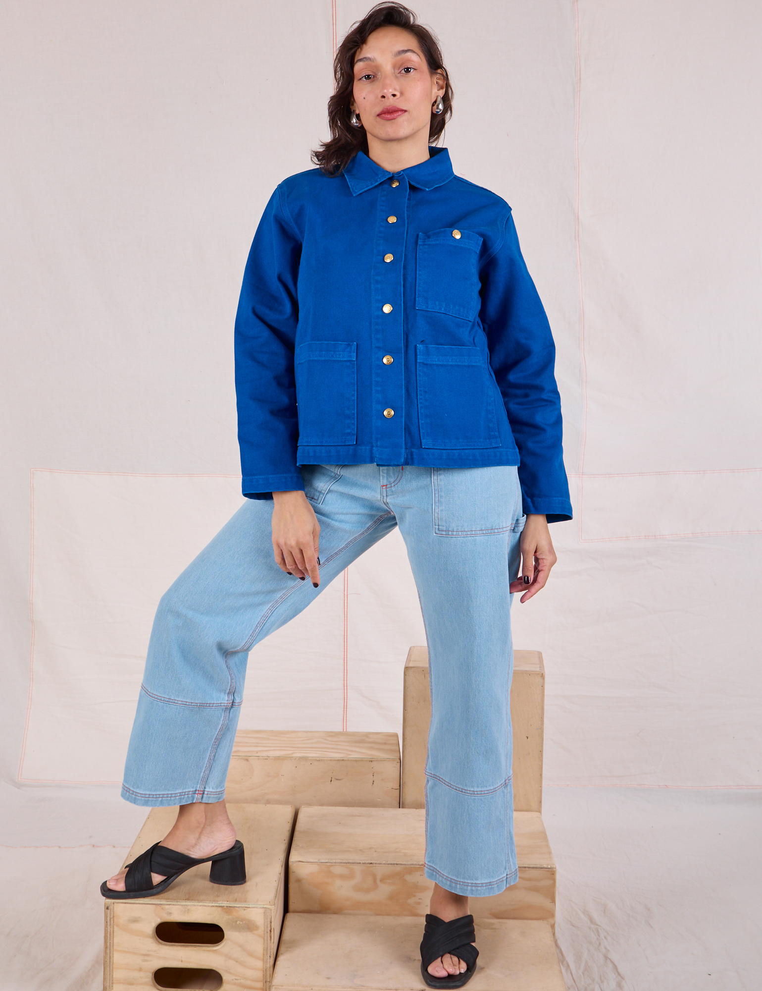 Tiara is wearing a buttoned up Denim Work Jacket in Royal Blue paired with light wash Carpenter Jeans