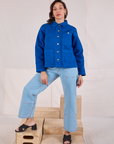 Tiara is wearing a buttoned up Denim Work Jacket in Royal Blue paired with light wash Carpenter Jeans