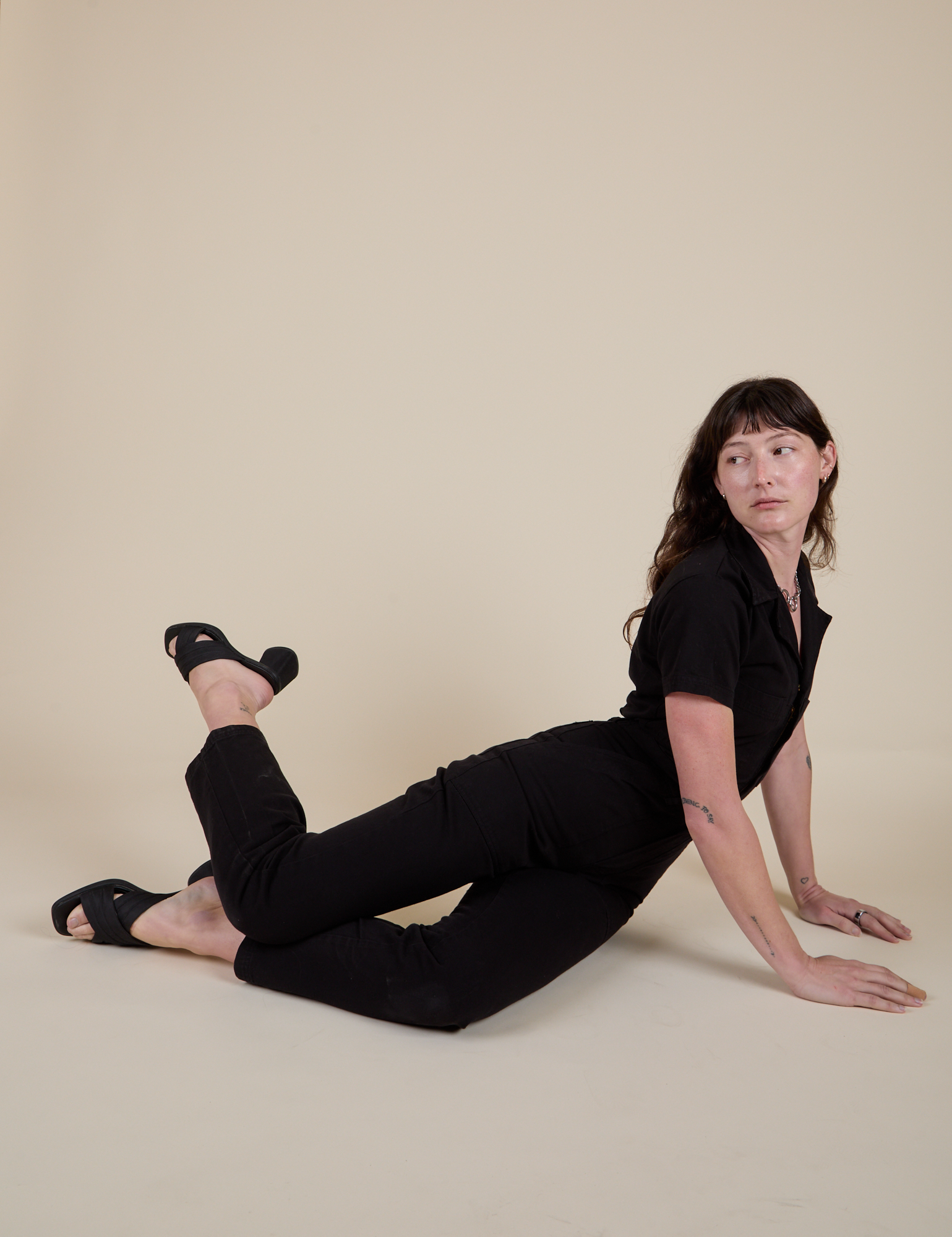 Alex is wearing Short Sleeve Jumpsuit in Basic Black