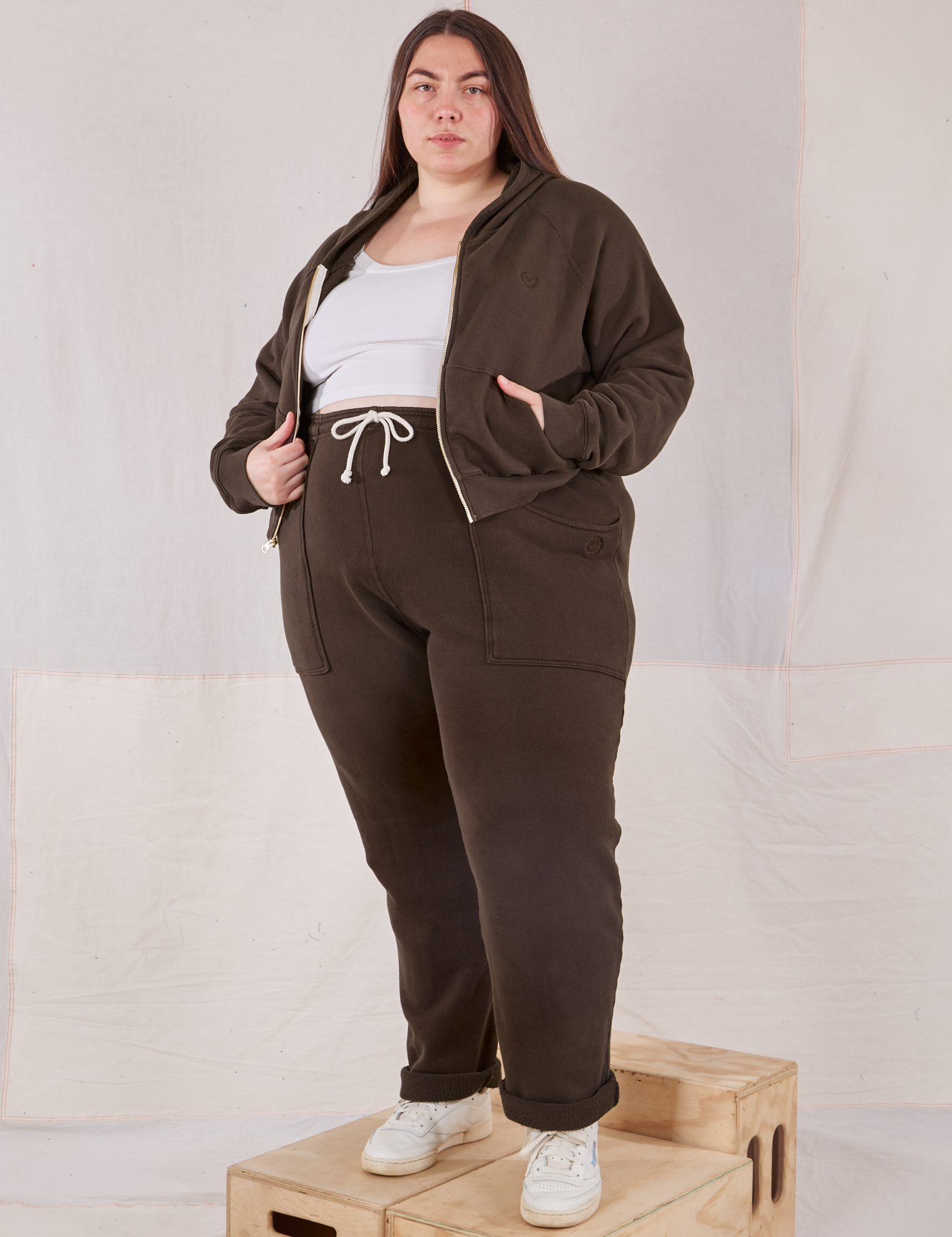 Marielena is 5&#39;8&quot; and wearing 1XL Rolled Cuff Sweat Pants in Espresso Brown with matching Cropped Zip Hoodie and a vintage off-white Cropped Tank underneath.
