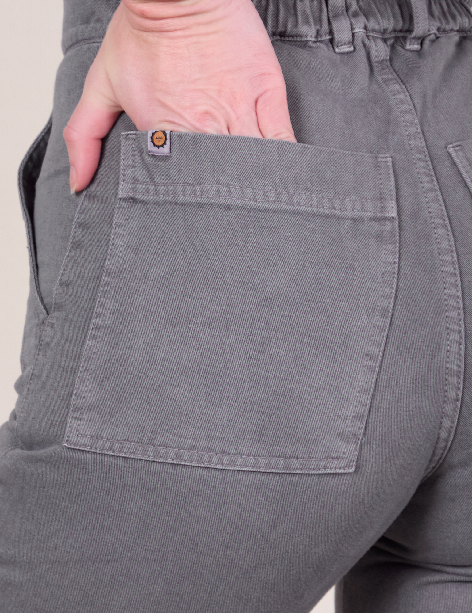 Short Sleeve Jumpsuit in Washed Grey back pocket close up on Alex