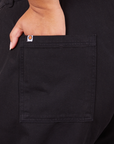 Back pocket close up of Western Pants in Basic Black. Alicia has her hand in the pocket