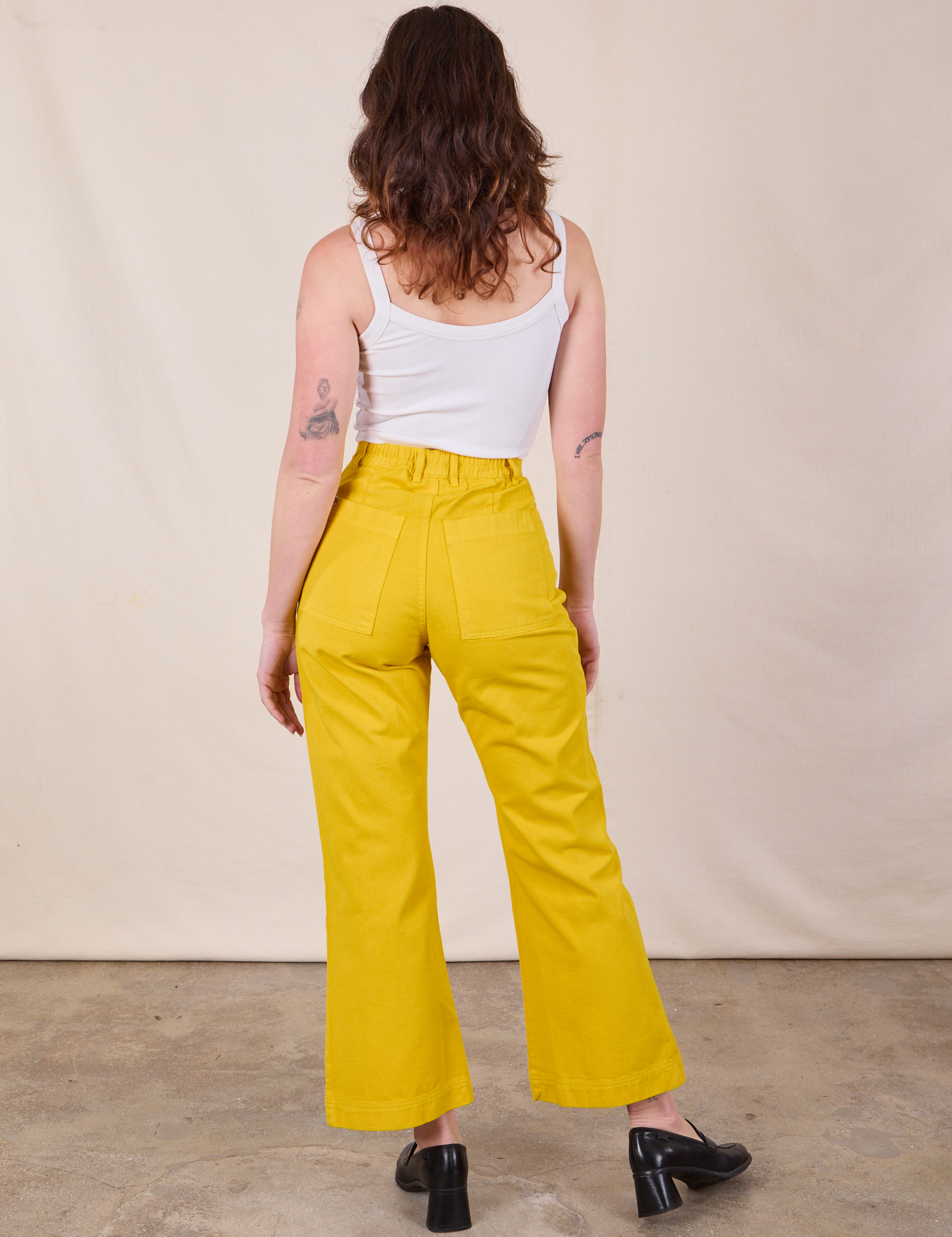 Back view of Western Pants in Golden Yellow and Cropped Cami in Vintage Tee Off-White on Alex