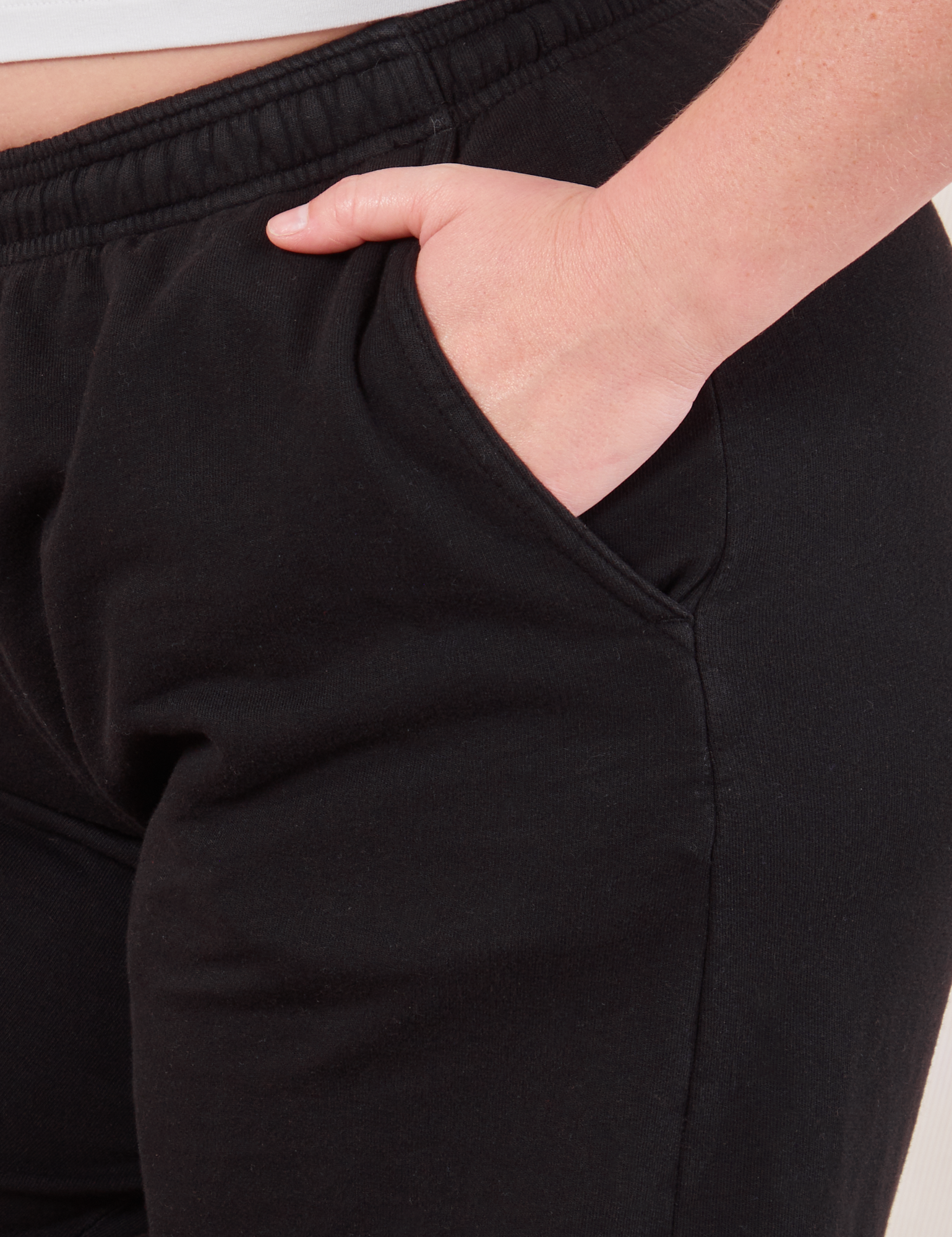 Wide Leg Sweat Pants in Basic Black side pocket close up with Lish&#39;s hand in it.