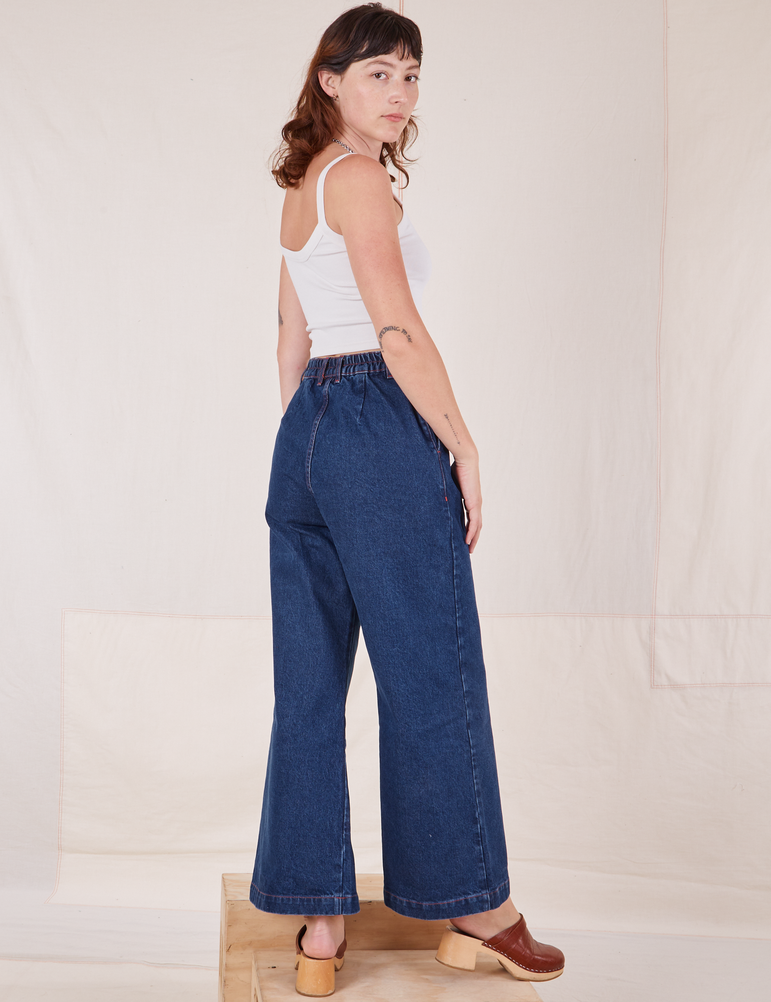 Angled back view of Indigo Wide Leg Trousers in Dark Wash on Alex