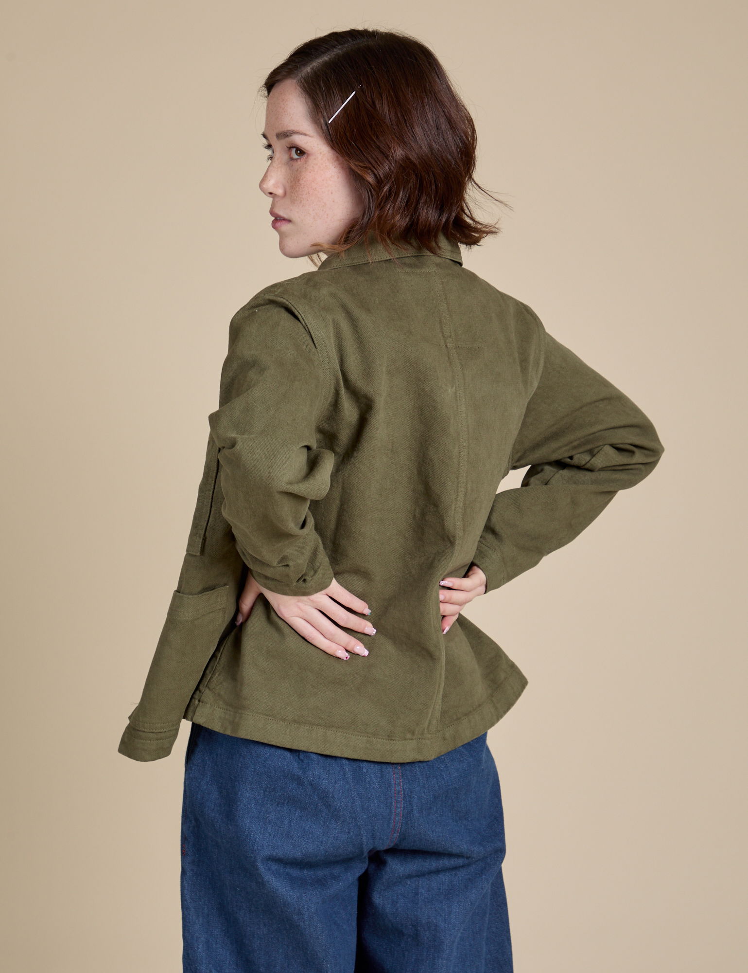 Angled back view of Denim Work Jacket in Surplus Green on Hana