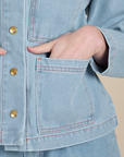 Close up of Alex's hand in the front pocket of Indigo Denim Work Jacket in Light Wash