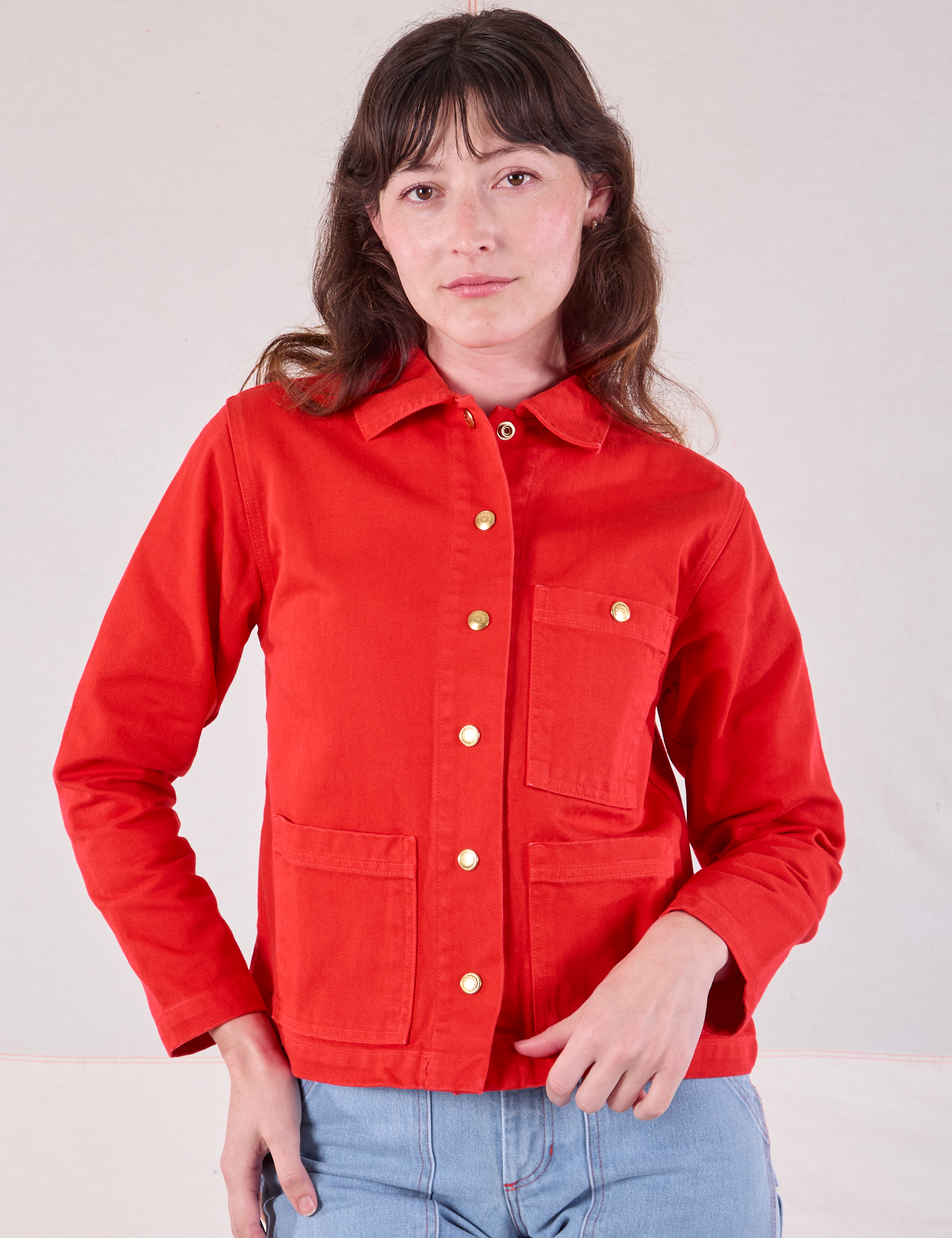 Alex is wearing a buttoned up Denim Work Jacket in Mustang Red