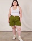 Ashley is 5’7” and wearing 1XL Classic Work Shorts in Summer Olive paired with a Cropped Tank Top in vintage tee off-white