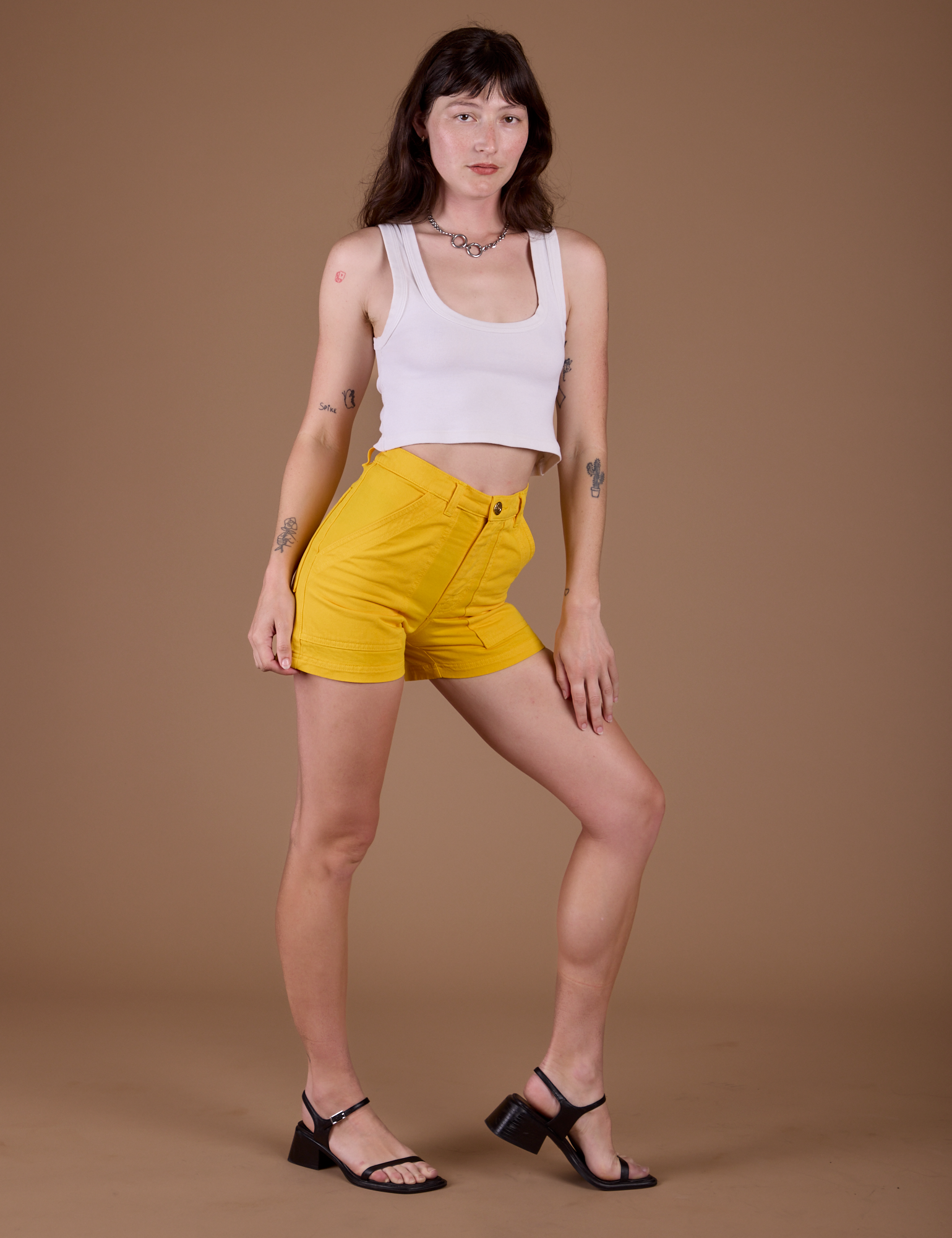 Angled front view of Classic Work Shorts in Sunshine Yellow and vintage tee white Cropped Tank on Alex