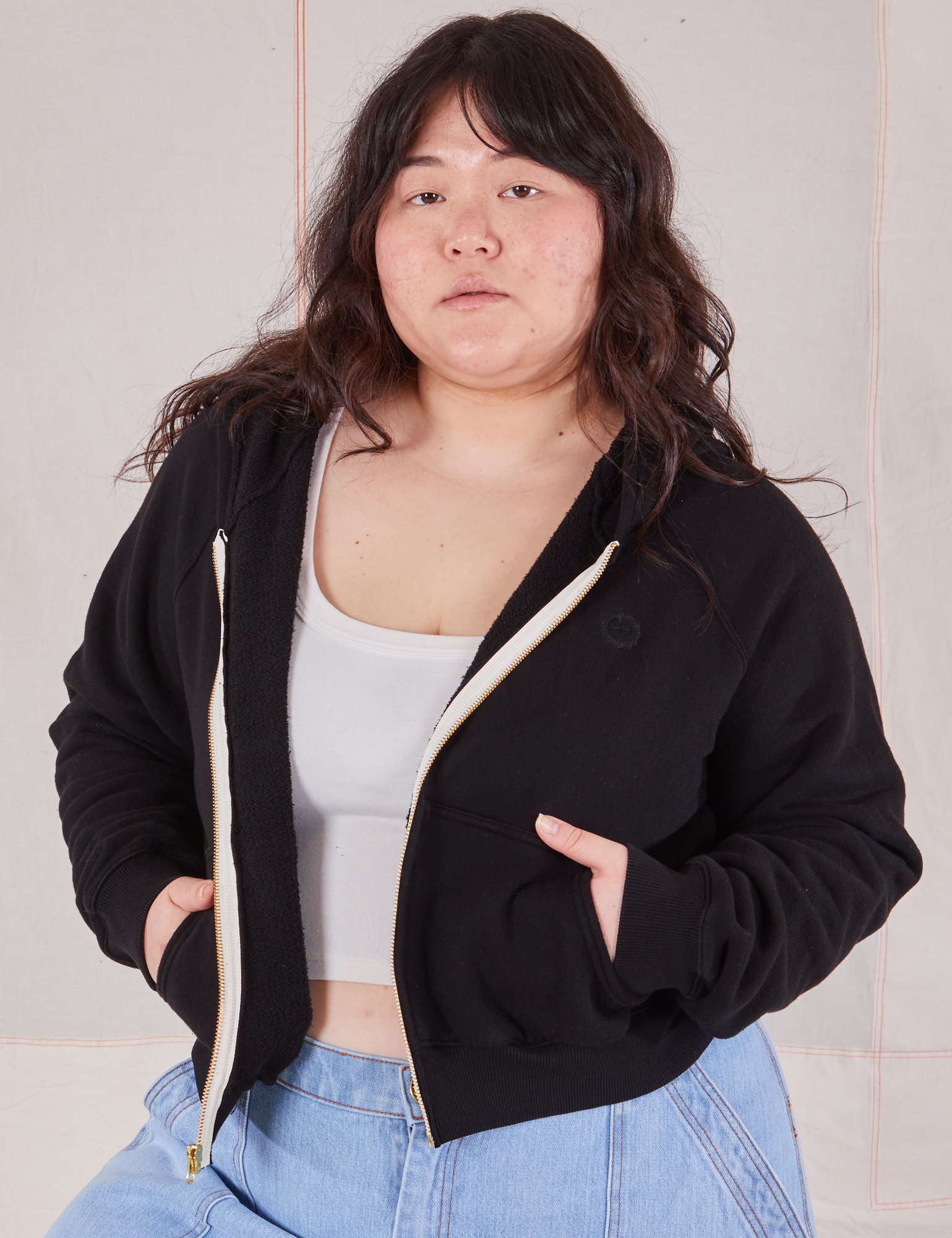 Ashley is 5&#39;7&quot; and wearing L Cropped Zip Hoodie in Basic Black with a vintage off-white Cropped Tank underneath