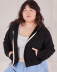Ashley is 5'7" and wearing L Cropped Zip Hoodie in Basic Black with a vintage off-white Cropped Tank underneath