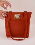 Over-Shoulder Zip Mini Tote in Paprika with model holding zipper